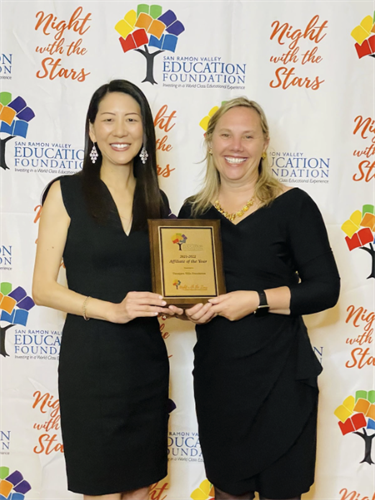 Two people posing with award